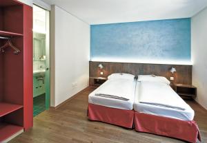 a bedroom with a bed and a painting on the wall at Sorell Hotel Arabelle Bern in Bern +4 photos