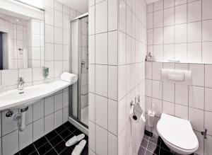 a white bathroom with a toilet and a sink at Sorell Hotel Arabelle Bern in Bern