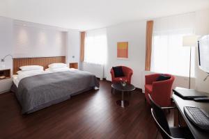 Un dormitorio con una cama y dos sillas y un escritorio. en Sorell Hotel Rütli Niederdorf Zürich, en Zúrich 15 fotos más