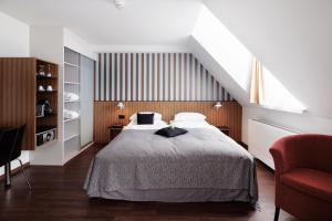 Un dormitorio con una cama grande y una silla roja. en Sorell Hotel Rütli Niederdorf Zürich, en Zúrich