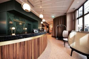 a restaurant with a bar with chairs and tables at Sorell Boutique-Hotel Seidenhof Zürich in Zurich