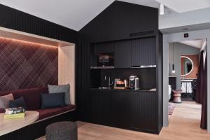 苏黎世Sorell Boutique-Hotel St Peter Zürich的客厅设有黑色墙壁和红色沙发 更多24张照片