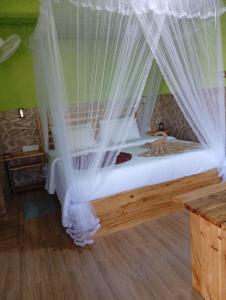 - une chambre avec un lit doté de moustiquaires blanches dans l'établissement NETHSARA cottage, à Ella