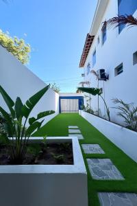 ein Garten mit Kunstrasen an der Seite eines Gebäudes in der Unterkunft Casa La France in Caucaia