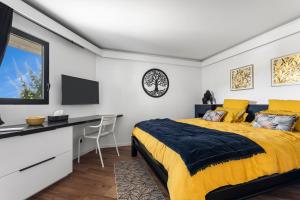 Un dormitorio con cama, escritorio y televisión. en NEW Villa 3ch et studio independant Jacuzzi vue mer, en Cul de Sac 25 fotos más