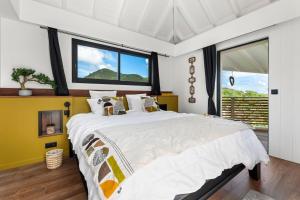 Un dormitorio con una cama grande y una ventana grande en NEW Villa 3ch et studio independant Jacuzzi vue mer, en Cul de Sac