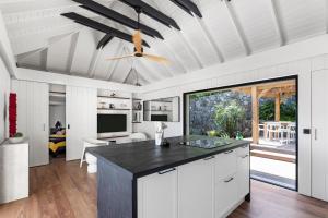 cocina con armarios blancos y ventilador de techo en NEW Villa 3ch et studio independant Jacuzzi vue mer, en Cul de Sac