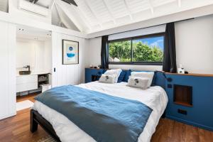 Un dormitorio con una cama azul y blanca y una ventana. en NEW Villa 3ch et studio independant Jacuzzi vue mer, en Cul de Sac