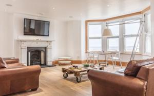 a living room with a couch and a fireplace at Seaview Penthouse 1 in Alnmouth
