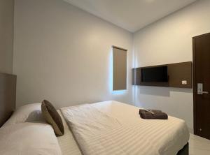 a bedroom with a bed and a flat screen tv at TJ Brother Residences Cengkareng in Jakarta +13 photos