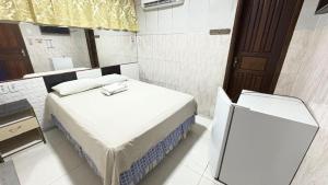 une petite chambre avec un lit et une télévision dans l'établissement Hotel Opção, à Manaus