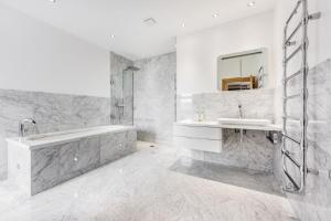 a white bathroom with a tub and a sink at Seaview Penthouse 1 in Alnmouth
