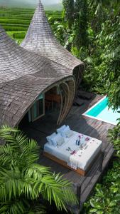 a bed sitting on a deck next to a pool at Jungleight Bali in Tegalalang