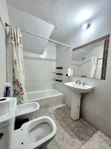 a white bathroom with a toilet and a sink at EL ESTABLO - Casa de Campo Vacacional con pileta privada - Jujuy in San Salvador de Jujuy