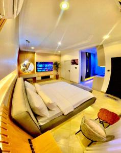 1 cama blanca grande en una habitación con TV en Royal Empire, en Abuja