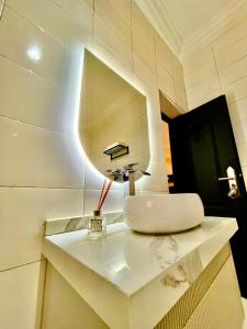 Un baño con un lavabo y un espejo sobre un mostrador. en Royal Empire, en Abuja