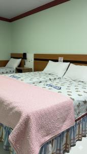 - un lit avec une couverture rose dans l'établissement Hotel Opção, à Manaus