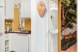 a kitchen with white cabinets and an umbrella on the wall at CasaSolemare Terrace seaview AC in Portovenere