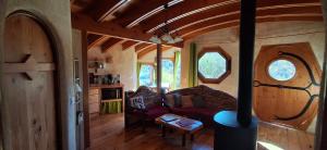 a living room with a red couch in a tiny house at Fount de Cousteno in Limbrassac