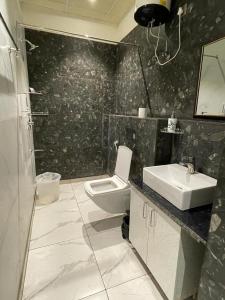 une salle de bains avec toilettes et lavabo dans l'établissement Hotel Golf Sakura, à Gurgaon