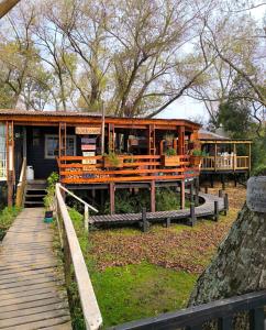 a house with a porch and a wooden walkway at casa alpina Maxi premiun in Tigre