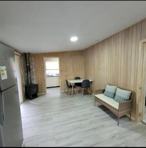 ein Wohnzimmer mit Sofa und Tisch in der Unterkunft Cabaña interior en el centro de llanquihue in Llanquihue