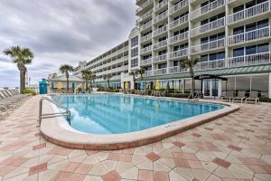 ein Schwimmbad vor einem großen Gebäude in der Unterkunft Daytona Beachfront Condo with Ocean View in Daytona Beach