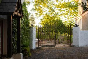 ein Eingangstor zu einem Haus mit Auffahrt in der Unterkunft Brackengarth House in Purdysburn