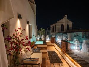 a balcony of a building with a pool at night at La Ermita Suites - Único Hotel Monumento de Córdoba in Córdoba