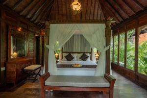 ein Schlafzimmer mit einem Bett in einem Zimmer mit Fenstern in der Unterkunft Aksmi Suites & Villas in Bedahulu