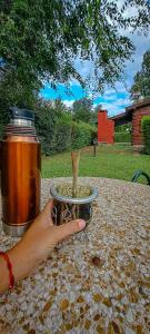 a person holding a bowl of food with a wooden spoon at Posta Magica in Villa Ciudad Parque +10 photos