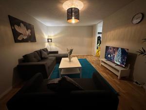 un salon avec un canapé et une table dans l'établissement Noah longstay Kungsfågelgatan, à Västerås