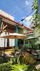 un patio con tavoli, sedie e ombrelloni di Hostal Brunette Santein a Santa Ana