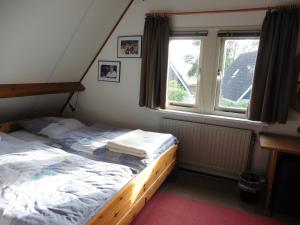 a bedroom with two beds and a window at Die Muschelfinder in Sint Maartensvlotbrug