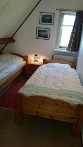 a bedroom with two beds and a window at Die Muschelfinder in Sint Maartensvlotbrug