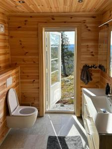 a bathroom with a toilet and a sink and a window at Mountain Cabin With Panoramic Views In Valdres in Bruflat
