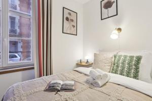 パリにあるBnBNova - 1BR - Les Invalides & Eiffel Tower-Family onlyのベッドルーム1室(書籍2冊、窓付)