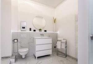 a white bathroom with a toilet and a mirror at Ferienwohnung Salinenparc Design Budget Hotel in Erwitte +18 photos