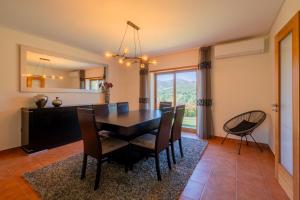 ein Esszimmer mit Tisch und Stühlen und einem Spiegel in der Unterkunft Brook House in Vieira do Minho