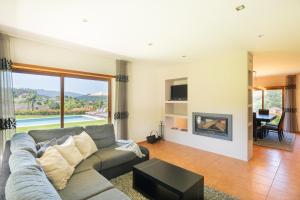 ein Wohnzimmer mit Couch und Kamin in der Unterkunft Brook House in Vieira do Minho