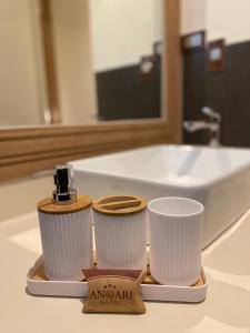 a couple of cups sitting on a bathroom counter at Anqari Hotel in San Antonio