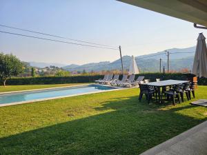 ein Tisch und Stühle neben einem Swimmingpool in der Unterkunft Brook House in Vieira do Minho