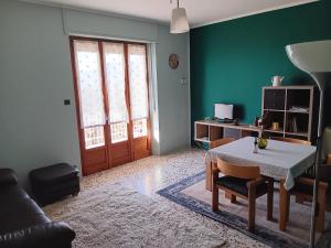 a living room with a table and a green wall at La Maison d'la Brumatera , ALLOGGIO CON 2 CAMERE DA LETTO E VISTA in Rubiana