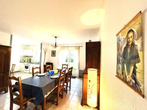 a dining room with a table and a painting on the wall at Maison 5 pièces 6 personnes à 10 minutes des plages in Clohars-Carnoët
