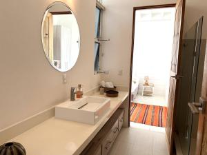 une salle de bains avec un lavabo blanc et un miroir dans l'établissement Ocean View Jungle Nest - 2min From The Beach, à Santa Teresa 29 autres photos
