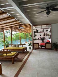 - un salon avec des canapés et un ventilateur de plafond dans l'établissement Ocean View Jungle Nest - 2min From The Beach, à Santa Teresa