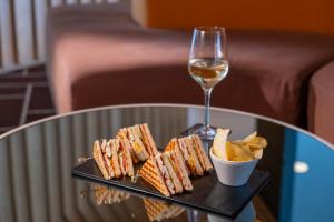 a table with a plate of food and a glass of wine at HF Fénix Urban in Lisbon