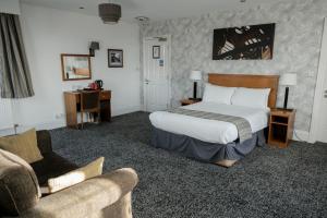 um quarto de hotel com uma cama e um sofá em Fairway Inn em Manchester