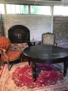 a living room with a table and two chairs and a fireplace at Loft en el quincho in Ingeniero Maschwitz