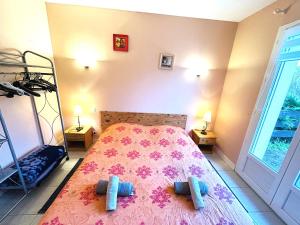 a bedroom with a bed with a pink bedspread at Maison 5 pièces 6 personnes à 10 minutes des plages in Clohars-Carnoët